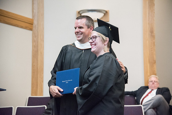 Graduate and Nathan J. Meeker smile for a photo at the Convocation for the Sociology and Social Work/Psychology Departments in the Hinckley Chapel. July 2018