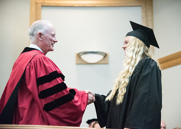 Graduates shake Elder Kim B. Clark's hand before being awarded their Diploma at Convocation of the Sociology and Social Work/Psychology in the Hinckley Chapel. July 2018