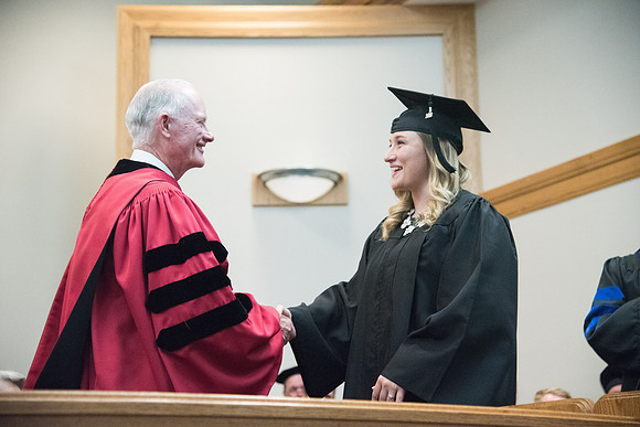 Graduates shake Elder Kim B. Clark's hand before being awarded their Diploma at Convocation of the Sociology and Social Work/Psychology in the Hinckley Chapel. July 2018