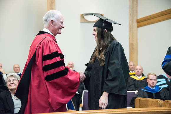 Graduates shake Elder Kim B. Clark's hand before being awarded their Diploma at Convocation of the Sociology and Social Work/Psychology in the Hinckley Chapel. July 2018