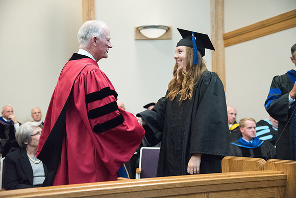 Graduates shake Elder Kim B. Clark's hand before being awarded their Diploma at Convocation of the Sociology and Social Work/Psychology in the Hinckley Chapel. July 2018
