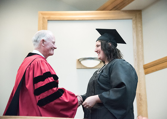 Graduates shake Elder Kim B. Clark's hand before being awarded their Diploma at Convocation of the Sociology and Social Work/Psychology in the Hinckley Chapel. July 2018