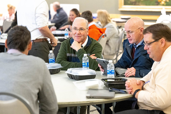 Faculty collaborate with each other over lunch.