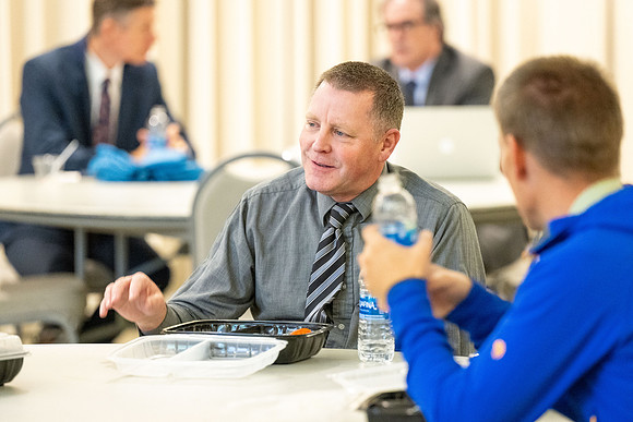Faculty collaborate with each other over lunch.