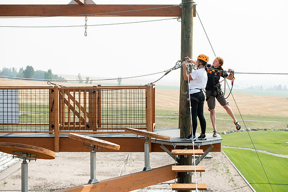 BYUI Students climbing around the ropes course by the upper fields in the summer of 2021.