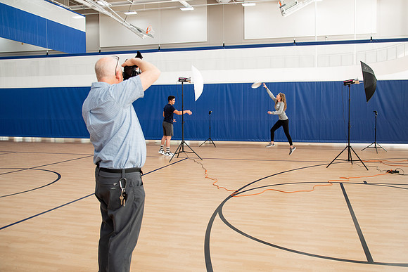 Behind the scenes of Mike Lewis shooting frisbee, football, and swimming photos for Hart gym decals.