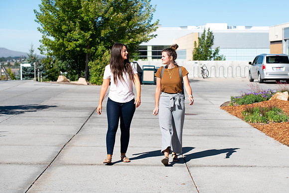 Examples of students staying safe and healthy during the COVID-19 pandemic by social distancing, following pathway arrows, and wearing face masks.