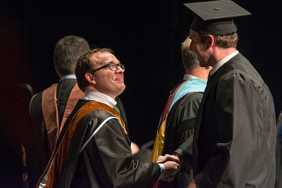 Faculty members hand degrees to and congratualate graduates of the College of Performing and Visual Arts.
