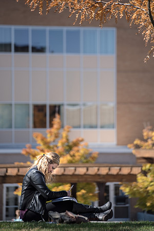 Student studying in between classes near the library.