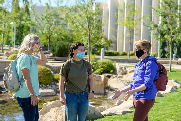Student volunteers show the way to stay safe during this COVID 19 pandemic by social distancing, following pathway arrows and proper wearing of masks .