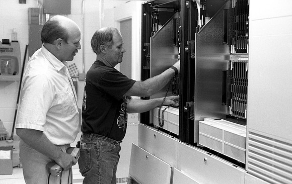 Employees check new switchboard telephone system.