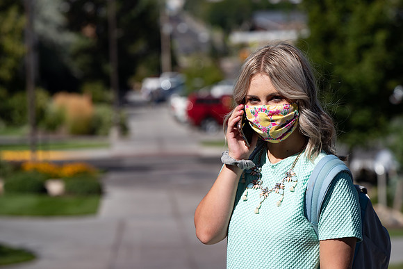 Examples of students staying safe and healthy during the COVID-19 pandemic by social distancing, following pathway arrows, and wearing face masks.