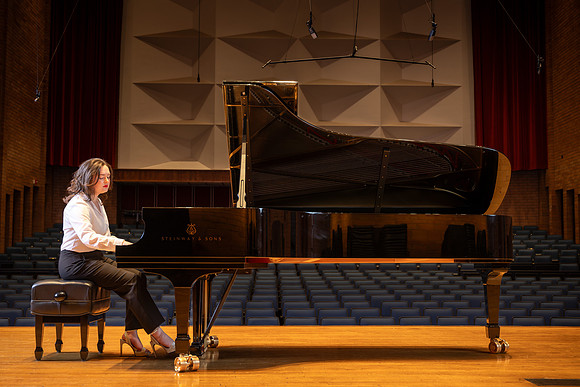Music major, Kaitlynd Ruesch at the grand piano preparing for here senior recital in the Barrus Concert Hall.