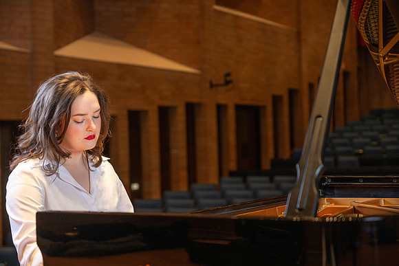 Music major, Kaitlynd Ruesch at the grand piano preparing for here senior recital in the Barrus Concert Hall.