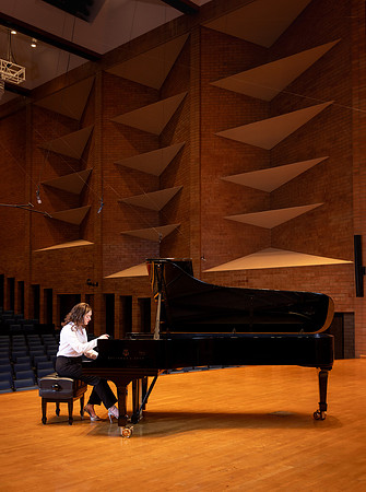 Music major, Kaitlynd Ruesch at the grand piano preparing for here senior recital in the Barrus Concert Hall.