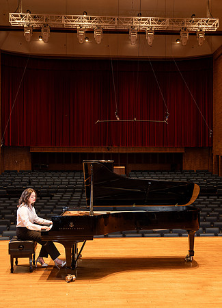 Music major, Kaitlynd Ruesch at the grand piano preparing for here senior recital in the Barrus Concert Hall.