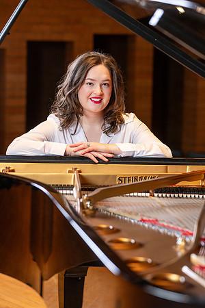 Music major, Kaitlynd Ruesch at the grand piano preparing for here senior recital in the Barrus Concert Hall.