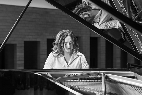 Music major, Kaitlynd Ruesch at the grand piano preparing for here senior recital in the Barrus Concert Hall.