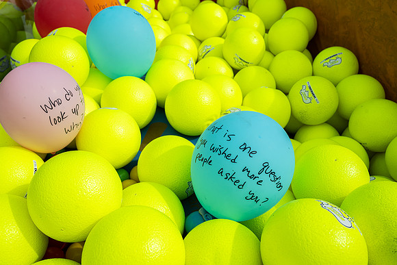 Students who volunteer to participate sit in the ball pit and ask each other questions which are found on the balloons. Video is being produced for Student Living.