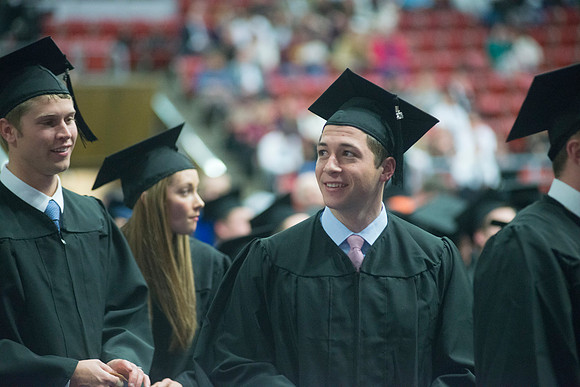 Elder W. Craig Swick and President Kim B. Clark award diploma covers to graduates in the College of Business and Communication.