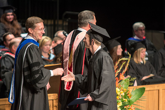 Faculty members hand degrees to and congratualate graduates of the College of Performing and Visual Arts.