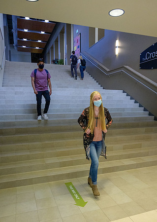 Student volunteers show the way to stay safe during this COVID 19 pandemic by social distancing, following pathway arrows and proper wearing of masks .