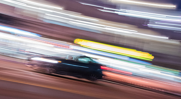 Cars streaking by. Camera pan with moving subject to accentuate motion.