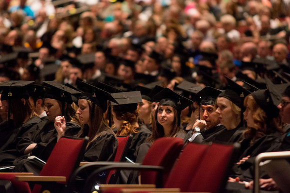 A student listens to speakers at the Brigham Young University-Idaho commencement ceremony with her fellow peers. Photo by Ryan Chase