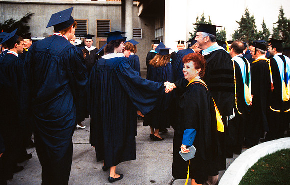 Graduates march into the Hart building during the processional. Jan Harrop and Nate Yearsley congratulate graduates