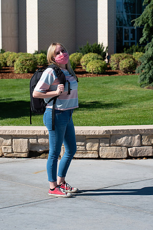 Examples of students staying safe and healthy during the COVID-19 pandemic by social distancing, following pathway arrows, and wearing face masks.