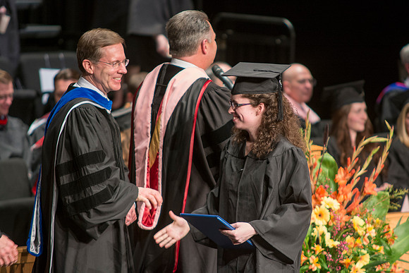 Faculty members hand degrees to and congratualate graduates of the College of Performing and Visual Arts.