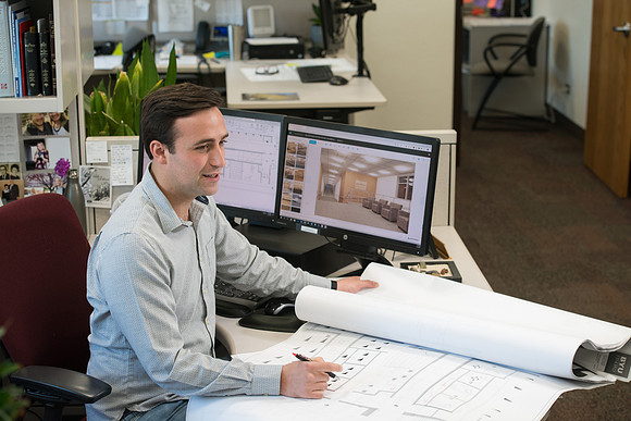 Sterling Kreutzer, a Construction Management major working with architectural drawings and 3D design at the University Operations Facility.