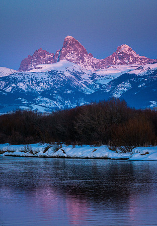 The Teton River winds through the valley below the Grand Teton Mountains.