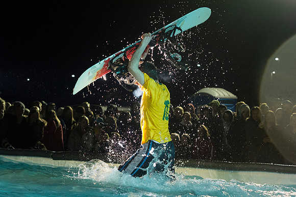 Students make a run down a snowy slope and across a pond of water in the annual event of Pond Skimming.