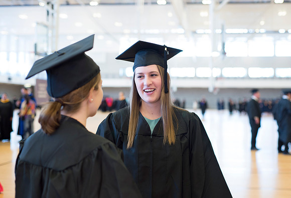 Graduates wait inside the gym area preparing to enter Commencement ceremony.