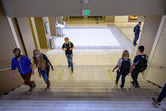Student volunteers show the way to stay safe during this COVID 19 pandemic by social distancing, following pathway arrows and proper wearing of masks .