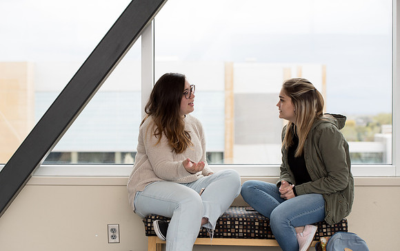 Students laugh together on the skybridge between the McKay Library and the Manwaring Center.