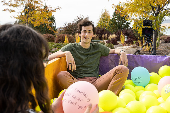 Students who volunteer to participate sit in the ball pit and ask each other questions which are found on the balloons. Video is being produced for Student Living.