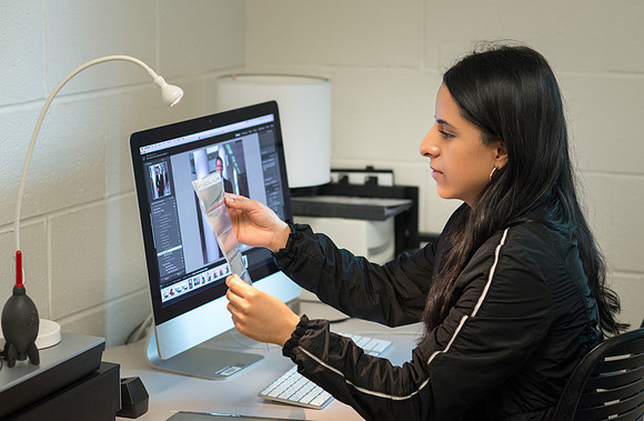 Ayelen Cervantes editing and archiving Ricks College era photos from slides and negatives.