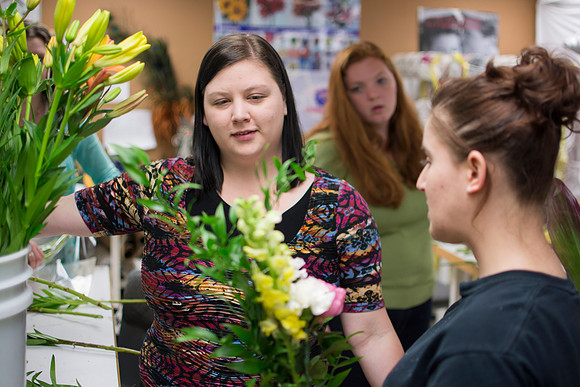 Horticulture students prepare for a semester review fashion show that will show their floral designs as well. Brother Romney leads the students along with other instructors.