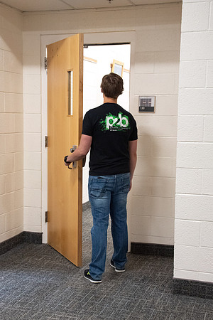 Examples of students staying safe and healthy during the COVID-19 pandemic by social distancing, following pathway arrows, and wearing face masks.