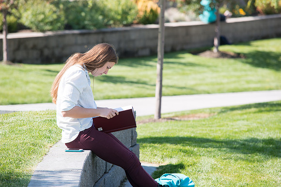 A student passes time between classes outside the MC Building, on the first day of school.