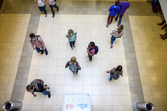 Student volunteers show the way to stay safe during this COVID 19 pandemic by social distancing, following pathway arrows and proper wearing of masks .