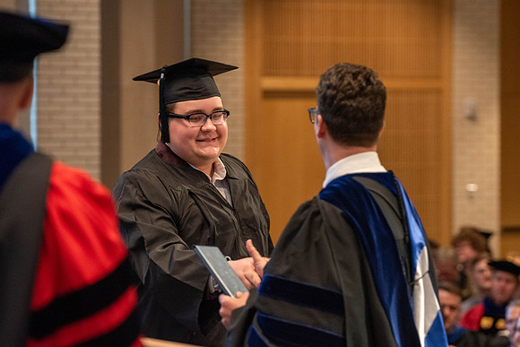 Students graduate from the College of Language and Letters. Jason Williams hands out the awards.