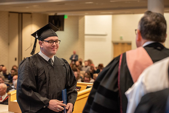 Students graduate from the College of Language and Letters. Jason Williams hands out the awards.