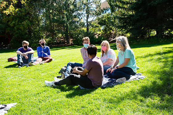 Examples of students staying safe and healthy during the COVID-19 pandemic by social distancing, following pathway arrows, and wearing face masks.