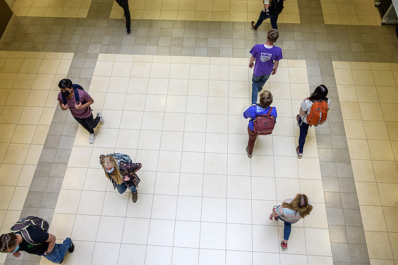 Student volunteers show the way to stay safe during this COVID 19 pandemic by social distancing, following pathway arrows and proper wearing of masks .