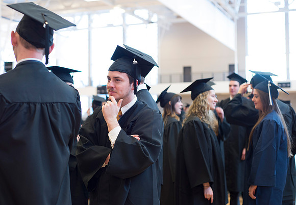 Graduates wait inside the gym area preparing to enter Commencement ceremony.