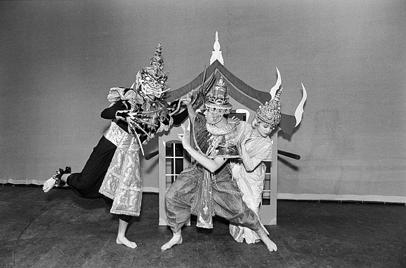 A man defending a lady from a amn with a mask.