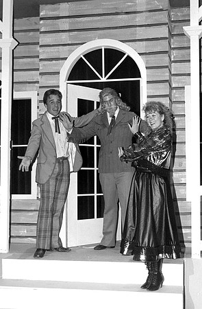 Actors standing on the porch.